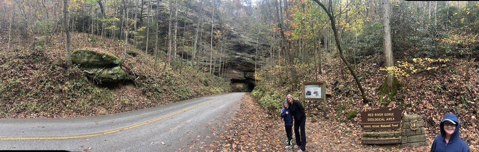 Nada Tunnel entrance in Red River Gorge, KY. People stand by a sign for the Red River Gorge Geological Area.