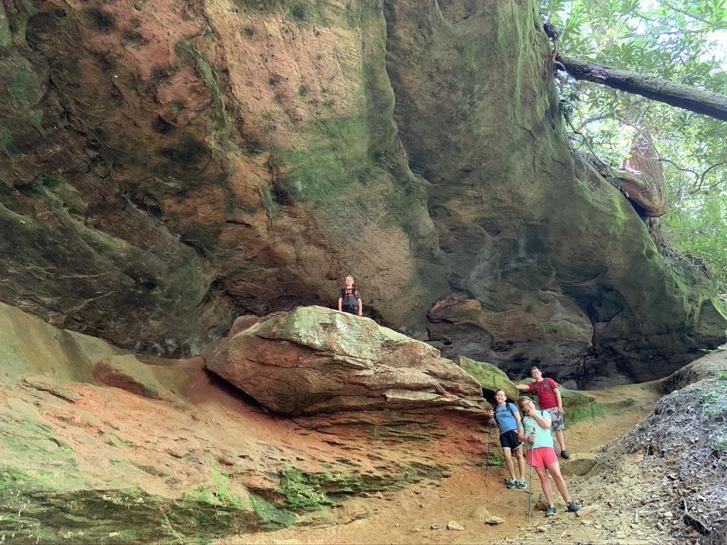 the red river gorge Family exploring a rock shelter at Red River Gorge, KY. Hiking adventure in Kentucky's natural beauty.